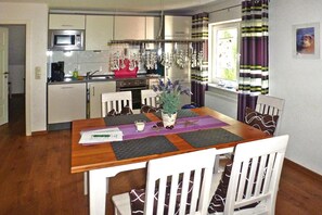 Enjoy meals in the kitchen with modern appliances, a dining area with a table for four, and a cozy atmosphere.