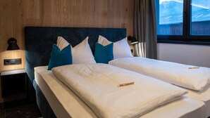A double bed with white and blue pillows, a wooden headboard, and a nightstand with a lamp. - Chalet in Wald im Pinzgau near Krimml Falls (Wald im Pinzgau)