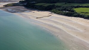 An aerial view of a coastal area with a wide sandy beach and a calm sea. - 2 Bed Sea View Apartment with Balcony Parking - Pass the Keys (Benllech)
