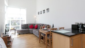 A modern apartment with a dining area, kitchen, and living space. - 2 Bed Sea View Apartment with Balcony Parking - Pass the Keys (Benllech)