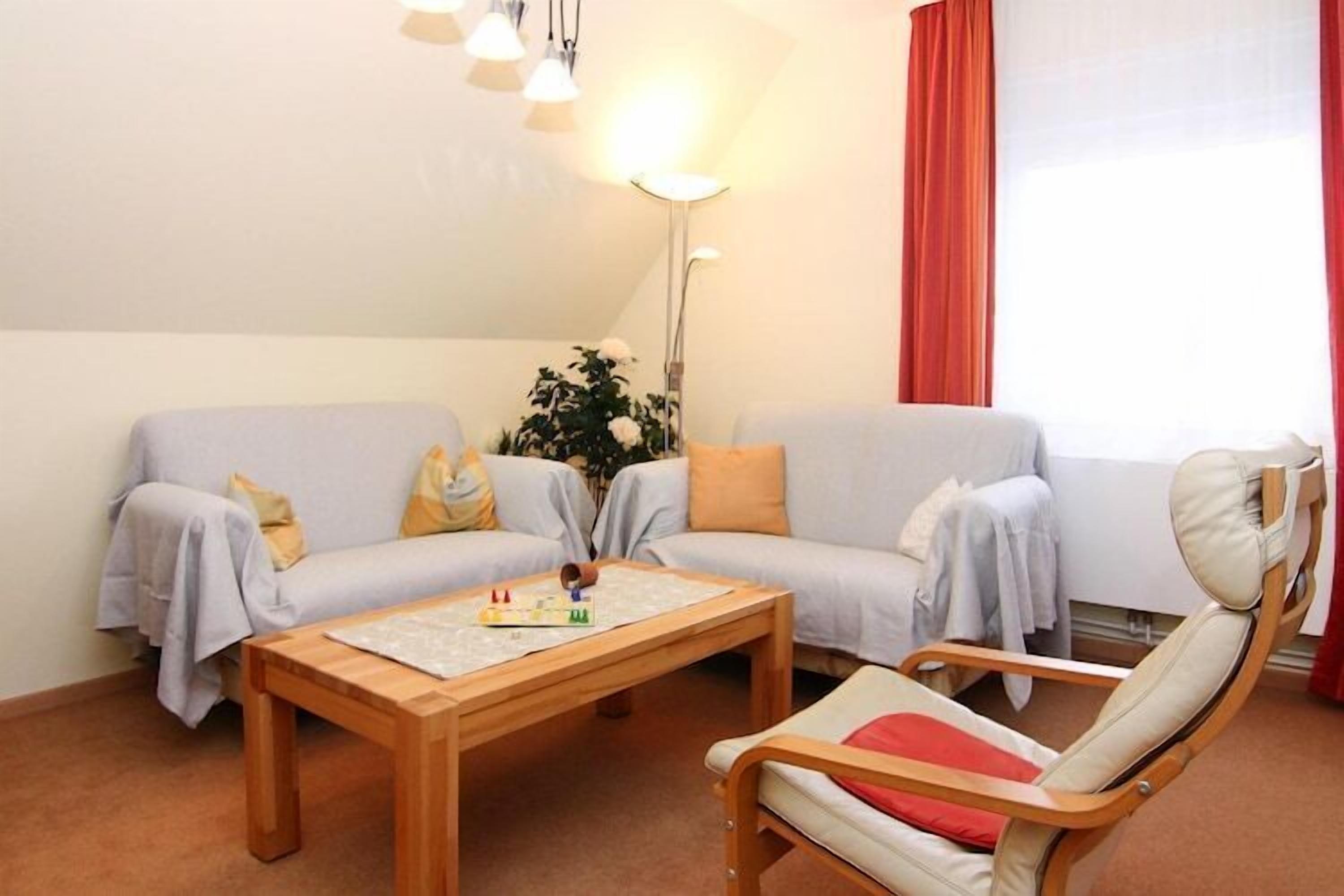 Una sala de estar con un sofá, una mesa de centro de madera y una silla.