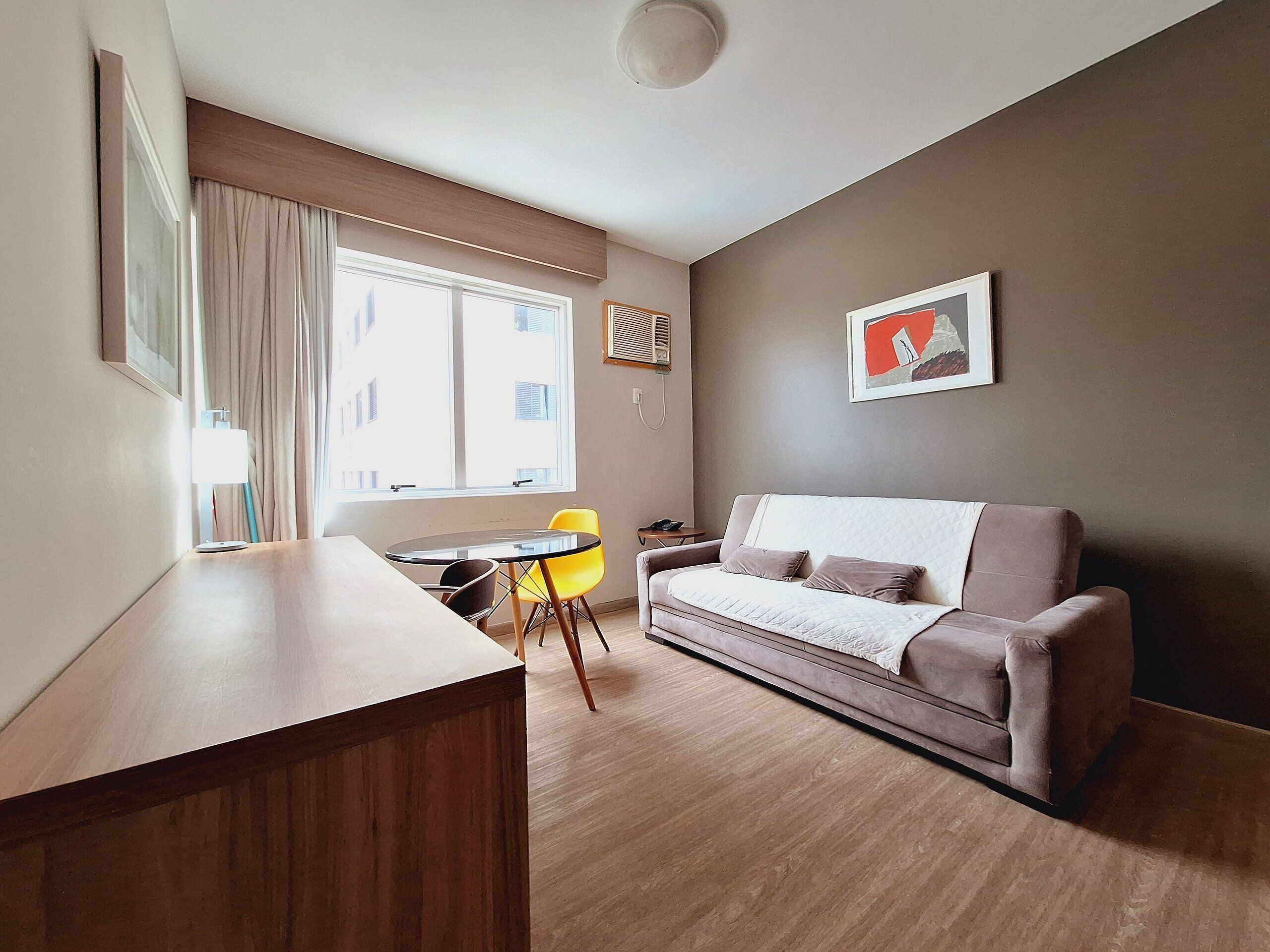 A modern living room with a sofa, a dining table, and a chair.