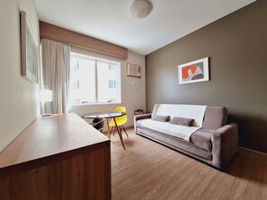 Una sala de estar moderna con un sofá, una mesa de comedor y una silla.