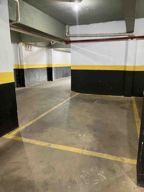 Un aparcamiento con suelo de hormigón y paredes pintadas de amarillo y negro.