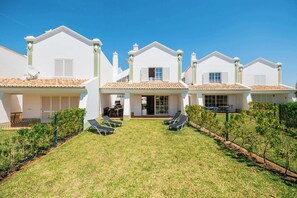 A row of white villas with tiled roofs, a grassy lawn, and a pool area with lounge chairs. - Beachsun Gale - beautiful villa close to beach (Galé)