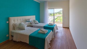 Una habitación con dos camas, un ventanal grande y vistas al paisaje.