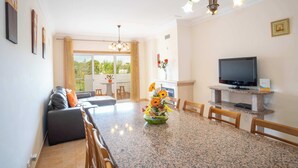 Una sala de estar moderna con sofá, mesa de comedor y televisor.