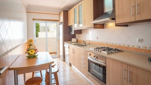 Una cocina moderna con armarios de madera, una estufa a gas y un lavamanos.
