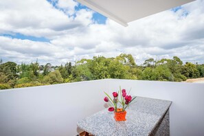 Enjoy a serene view of the lush landscape from this balcony.