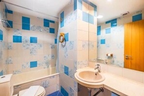 Banheira, secador de cabelo, toalhas de banho 