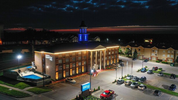 Un hôtel doté d’une piscine, d’un parking et d’une tour dont les fenêtres sont illuminées.