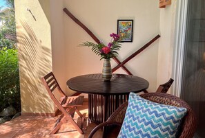 Une table ronde entourée de chaises, un vase rempli de fleurs et un tableau encadré accroché au mur.
