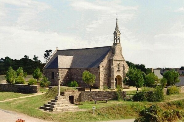 Una iglesia de piedra con un campanario y una escalera que lleva a la entrada.