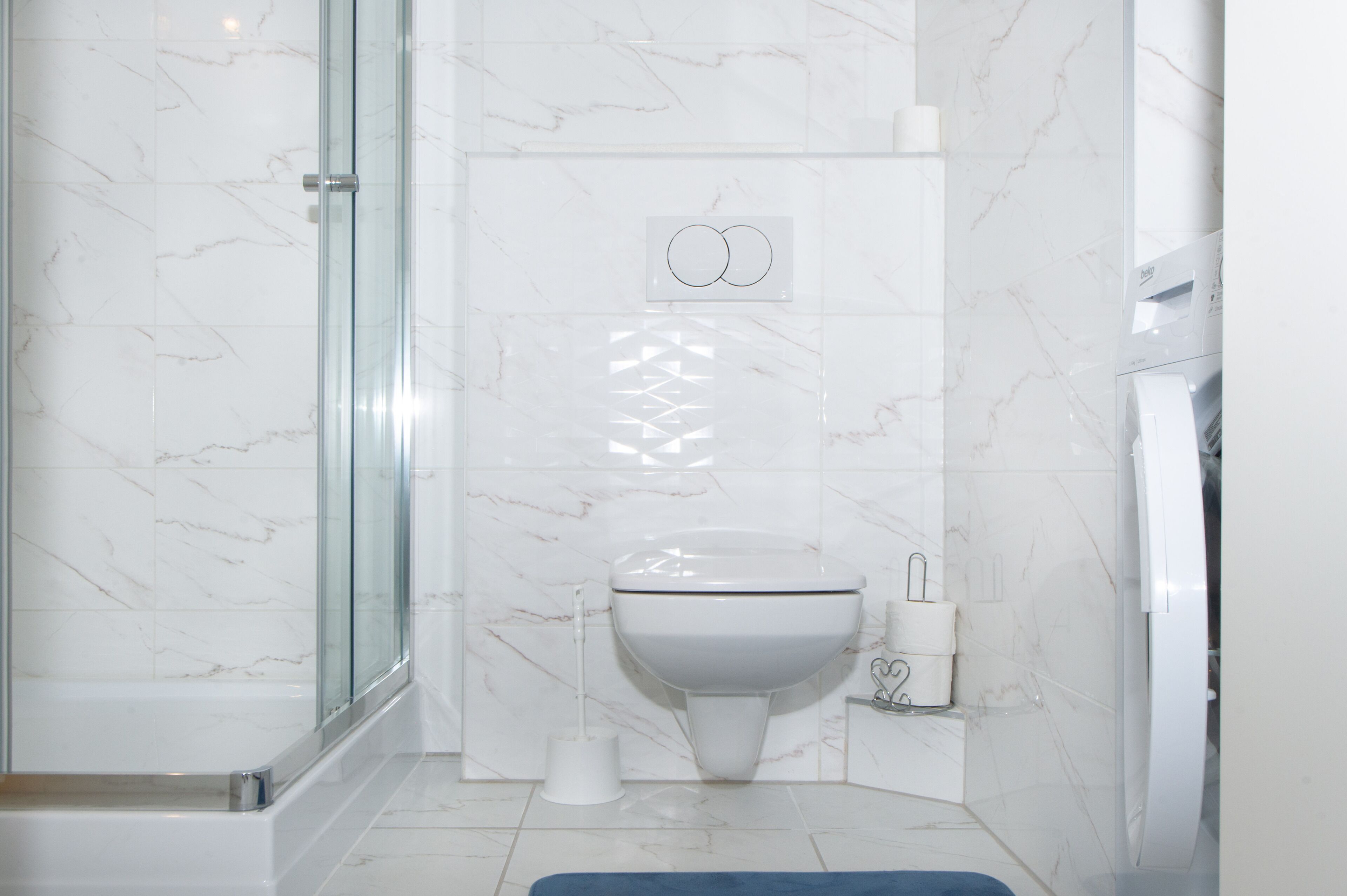 Een badkamer met een douchecabine van glas, een toilet en een bidet.