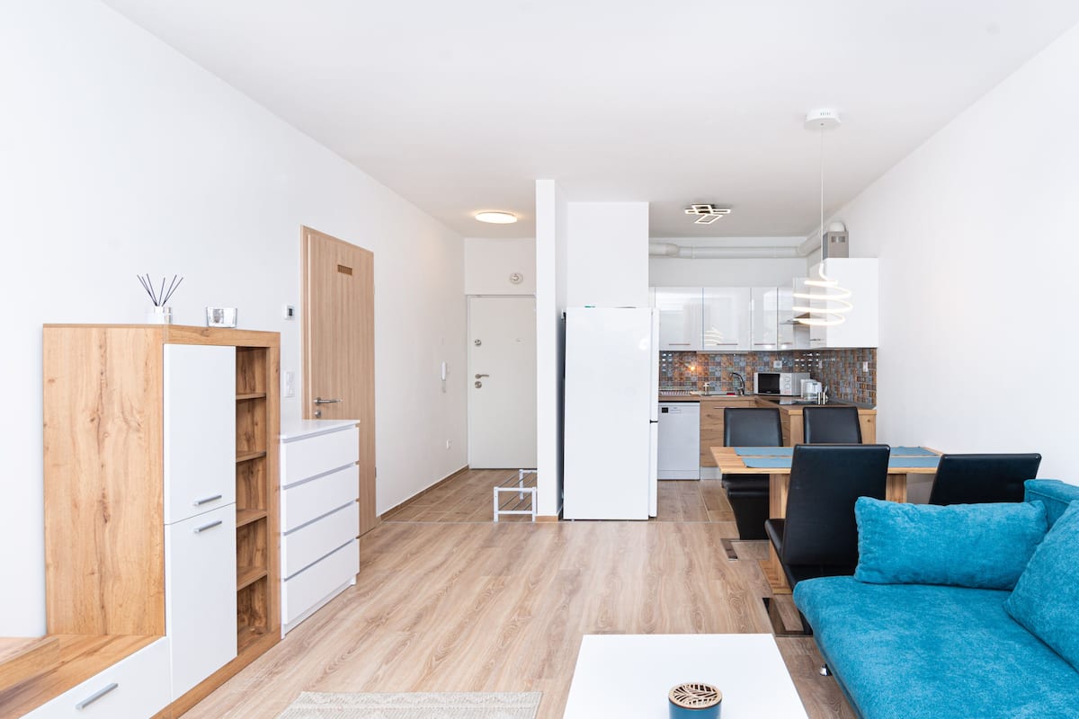 A modern apartment with a kitchenette, a dining area, and a living room.