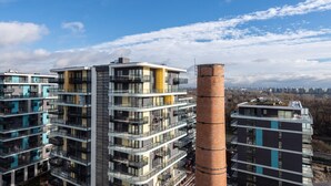 A high-rise residential building with multiple balconies and a prominent chimney. -  WaterFront City Apartments by FirstHost (Budapest)