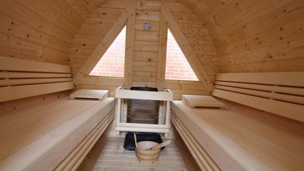 Uma sauna com bancos de madeira e um banco central com aquecedor.