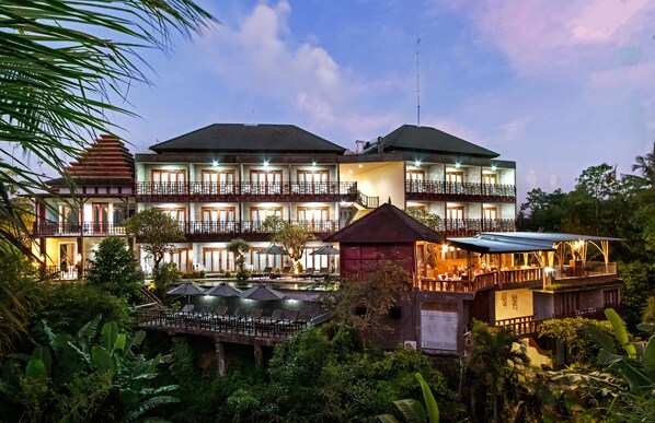 A multi-story hotel with outdoor seating and a pool area. - Mayura Ubud Retreat (Mas)