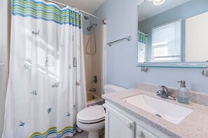 Une salle de bain avec une douche, des toilettes et un lavabo.