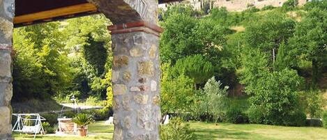 A stone structure with a view of a lush green landscape and a distant hill.