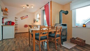 A cozy kitchen with a dining table, chairs, a stove, and a window with a view. - Ferienwohnungen am Plauer See, Zislow (Zislow)
