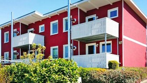 A red building with white balconies and multiple windows. - Ferienwohnungen am Plauer See, Zislow (Zislow)