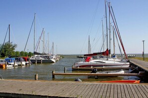 A marina with multiple sailboats docked at wooden piers.