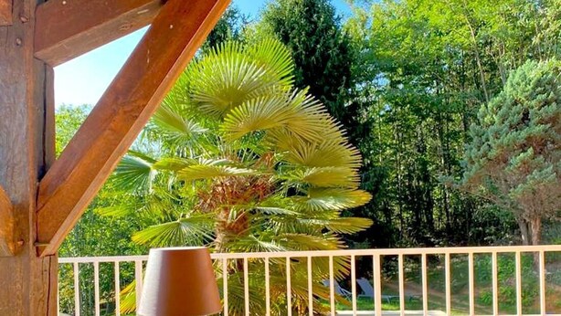 An outdoor dining area with a table set for two, a glass bowl, and a lamp. - Charming cottage  in the heart of nature with panoramic views  (Journiac)