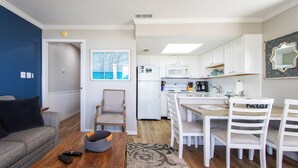 Un espace de vie compact comprenant une cuisine, un coin repas et un salon.