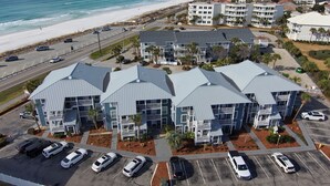 Un hôtel situé sur la côte, composé de plusieurs bâtiments, doté d’un parking et offrant une vue sur la plage.