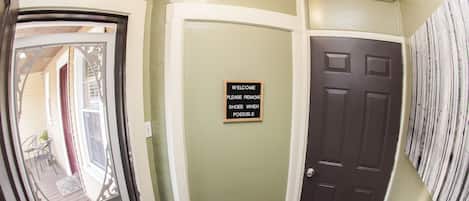 A hallway with a door, a sign, and a window.