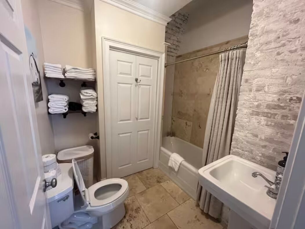 A compact bathroom with a toilet, sink, and shower.
