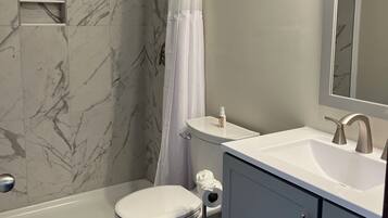 A bathroom with a bathtub, toilet, and sink.