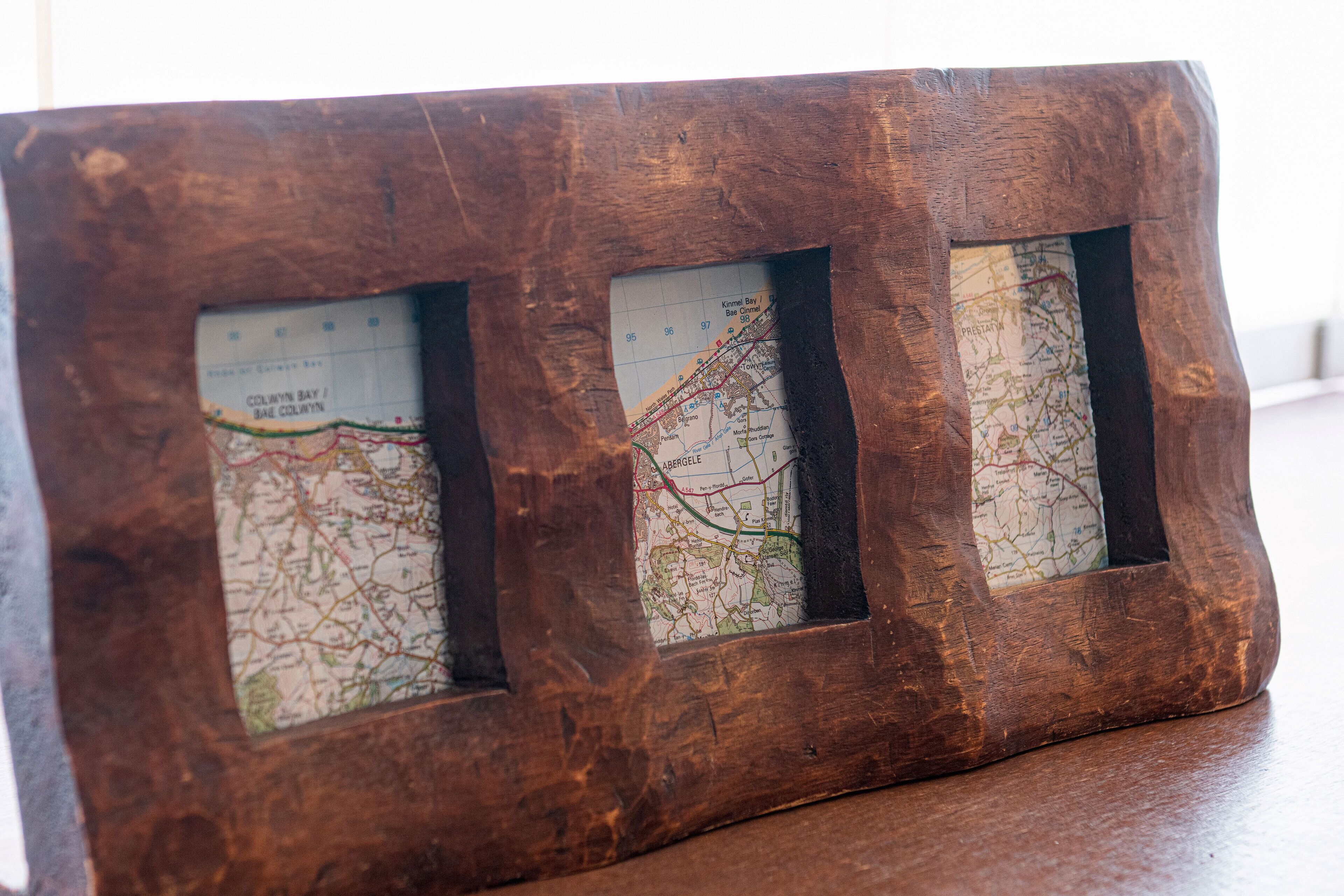 A wooden frame with three maps.