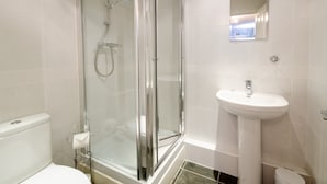 A modern bathroom with a glass-enclosed shower, a white sink, and a toilet. - 18 Thrang Brow - Two Bedroom House, Sleeps 4 (Ambleside)