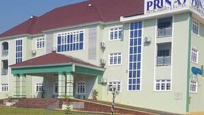 A multi-story building with a sign reading "PRINAJ HOTEL, RESORT & SUITES."