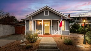 Une maison de plain-pied avec un porche à l’avant, le numéro « 403 » bien visible sur la porte et un drapeau sur le côté droit.