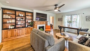 A living room with a fireplace, a large bookshelf, and a dining area. - Bloomington Bungalow - Steps to Campus! (Bloomington)