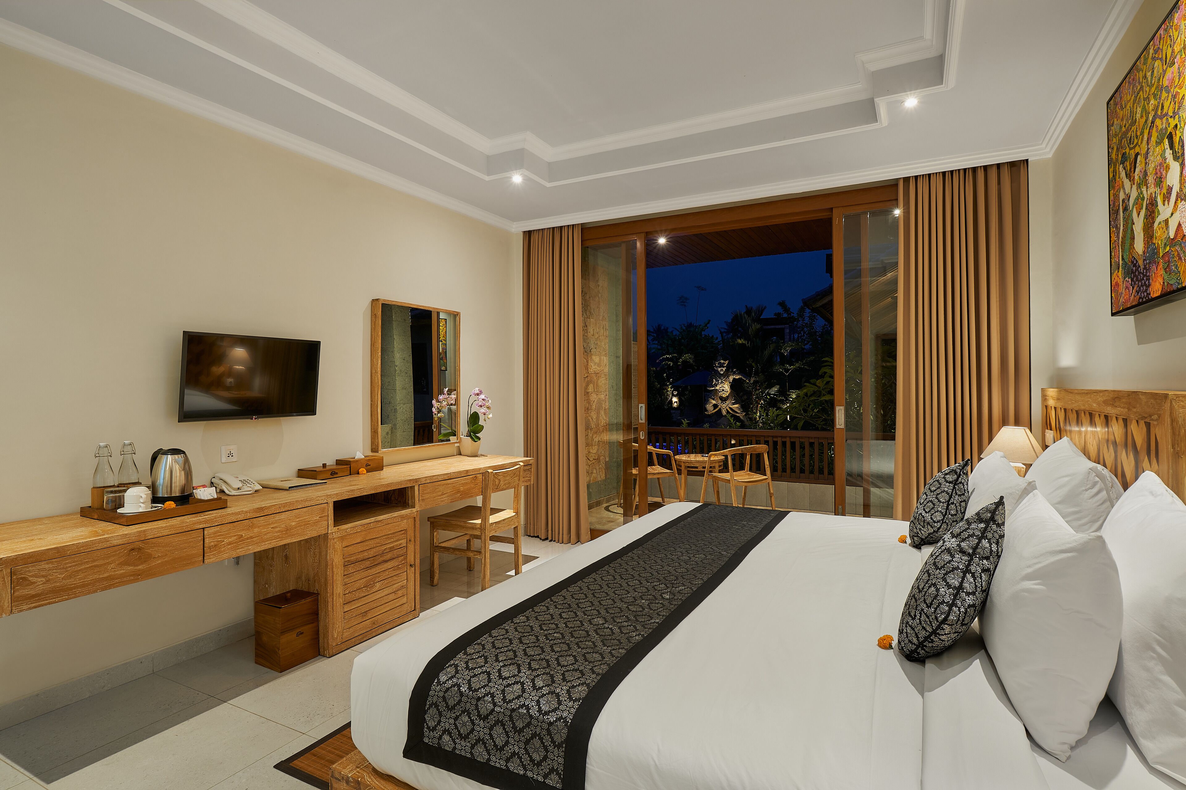 Une chambre d’hôtel moderne dotée d’un grand lit, d’un bureau en bois, d’une télévision à écran plat et d’un balcon avec des rideaux.
