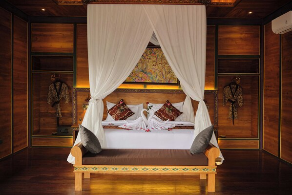 Cama com dossel, duas almofadas decorativas e cabeceira estampada com motivos florais.