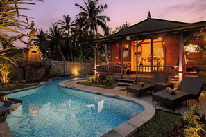 Uma área de piscina com espreguiçadeiras e um espaço coberto para relaxar.
