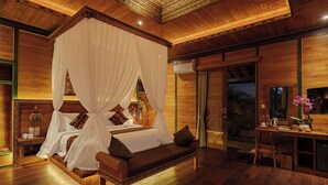 Una habitación amplia con una cama grande, un escritorio y vistas al exterior.