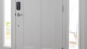 Une porte double blanche, dotée d’un clavier pour ouvrir et fermer à clé, et d’une petite fenêtre située au-dessus.