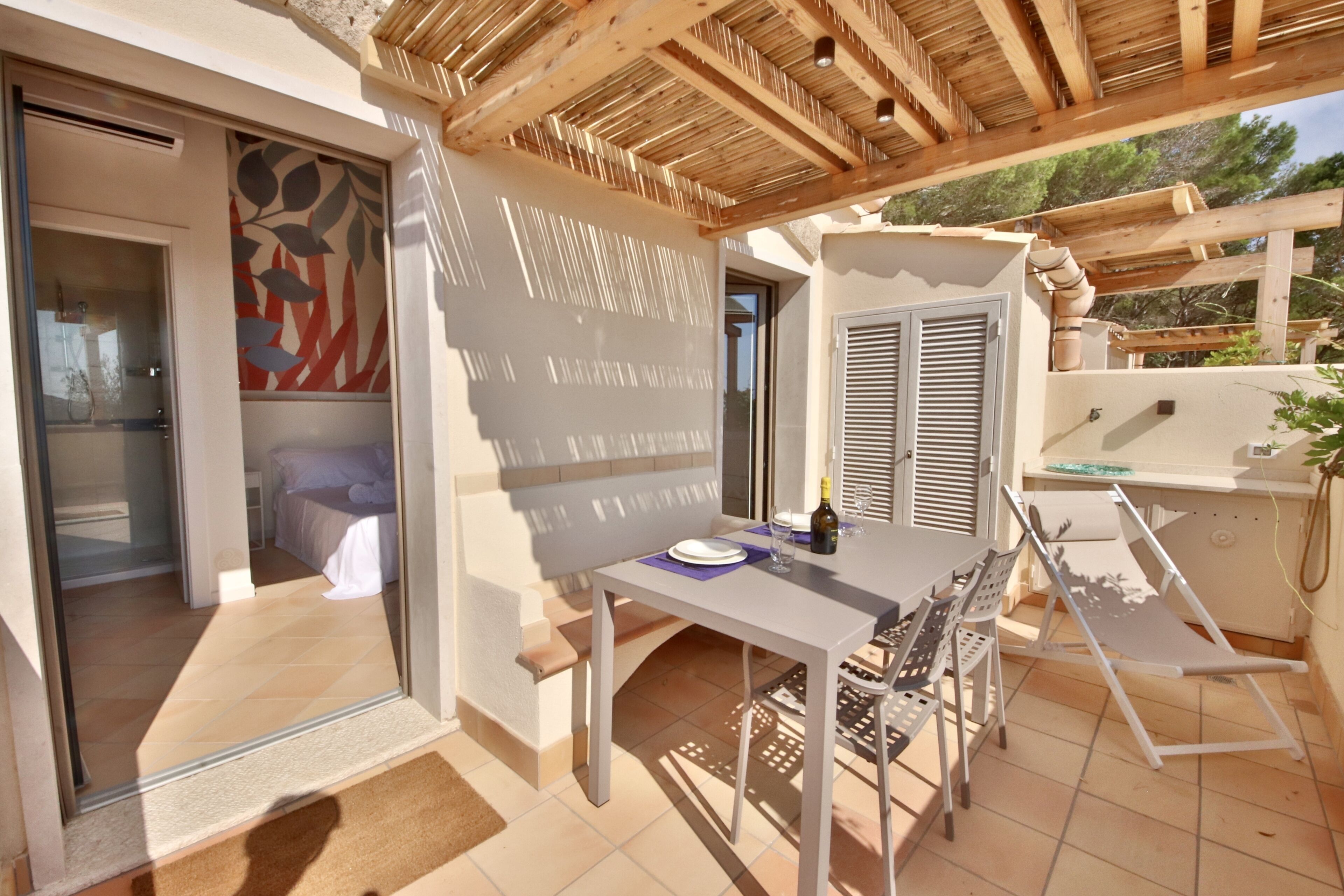 Eine Terrasse mit Tisch, Stühlen und einer Pergola.