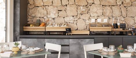 A breakfast bar with stone wall backdrop, wooden counter, and glass display cases.