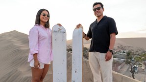 Two people standing on a sand dune with a surfboard between them. - Hotel La Estancia Ica (Ica)