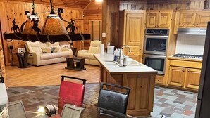 A wooden interior with a dining area, kitchen, and living room.
