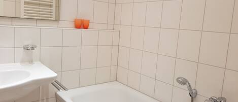 A bathroom with a bathtub, a sink, and a shower.