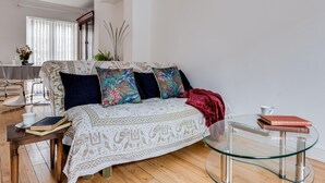 A modern living room with a sofa, a glass coffee table, and a dining area in the background. - Bright Spacious 2-bedroom Jericho House (Oxford)