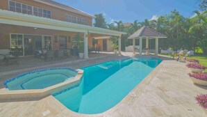 A swimming pool with a tiled deck, a covered patio area, and a gazebo. - Large Golf View Villa With Pool Jacuzzi and Staff (Punta Cana)